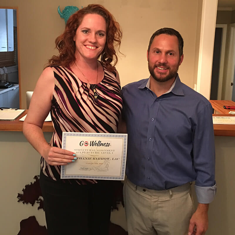 Regan poses with GoWellness Practitioner holding a certificate of completion for GoWellness Training